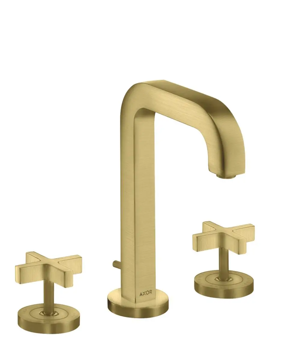 Waschtischarmatur von AXOR mit einem hohen, gebogenen Auslauf und zwei Kreuzgriffen. Die Oberfläche ist in Brushed Brass gehalten, unterhalb befinden sich Rosetten und eine Zugstangen-Ablaufgarnitur.